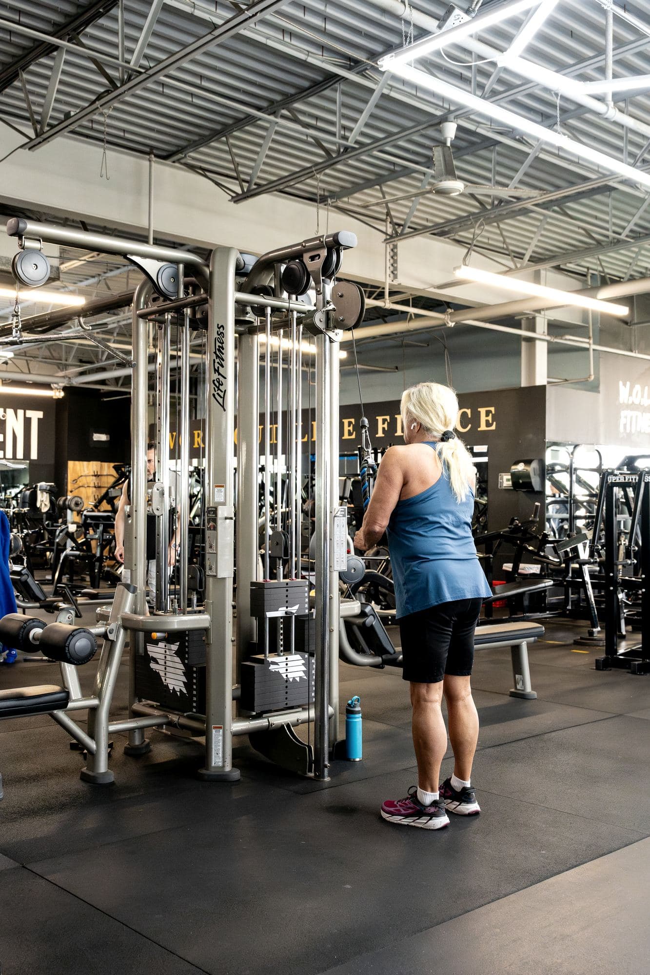 A member works a cable station on the training floor at an existing W.O.L.F. Gyms location (source photo Brig-8.JPG).